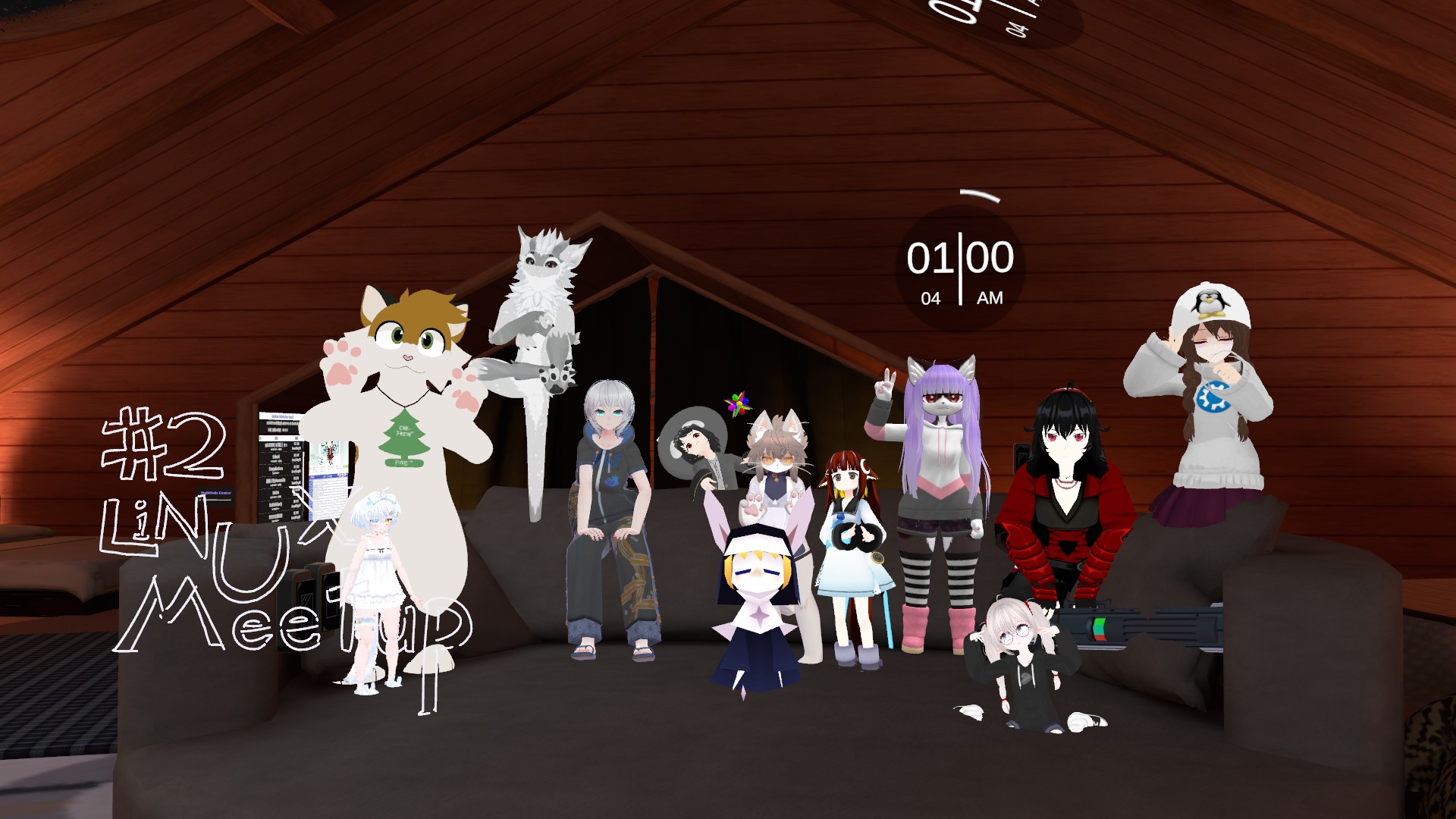 A screenshot from VRChat, timestamped 2024-10-06_01-00-04, depicting a group of 12 anthropomorphic and anime-style avatars posing together in a cozy, dimly lit attic-like room with wooden walls, beams, and a dark gray couch in the background. The room has warm reddish-brown lighting and a starry night sky visible through an upper window. Key elements: Drawn text in midair (left side): #2 in large white numbers, 'Linux Meetup' in stylized white letters below it. Timestamp (top-right): '01:00:04 AM' in white digital clock format. Avatars (from left to right, approximate positions): Furry fox-like character (orange-brown fur, white accents, green eyes, paw hands raised, wearing a Christmas tree necklace); Tall white furry wolf (grayish-white fur, expressive face); Short white bunny-girl (odd eyes, white dress); Human (silver hair, blue eyes, hoodie, baggy pants, sandals); Black-haired rabbit girl; Brown cat-girl (orange eyes, suit-like outfit); Purple-haired cat-girl in a futuristic hoodie; Black-haired girl (red eyes, black/red dress); Penguin-hatted girl (white sweater with Kubuntu logo, peace sign pose); Small blonde nun (with rabit ears); 
Red-haired girl in a sailor-like dress with white head accessories; Short white-haired girl holding a gatling gun, hands up. The group is posing for a group photo during a Linux Meetup event (#2), with playful and varied expressions and gestures like peace signs and raised paws.