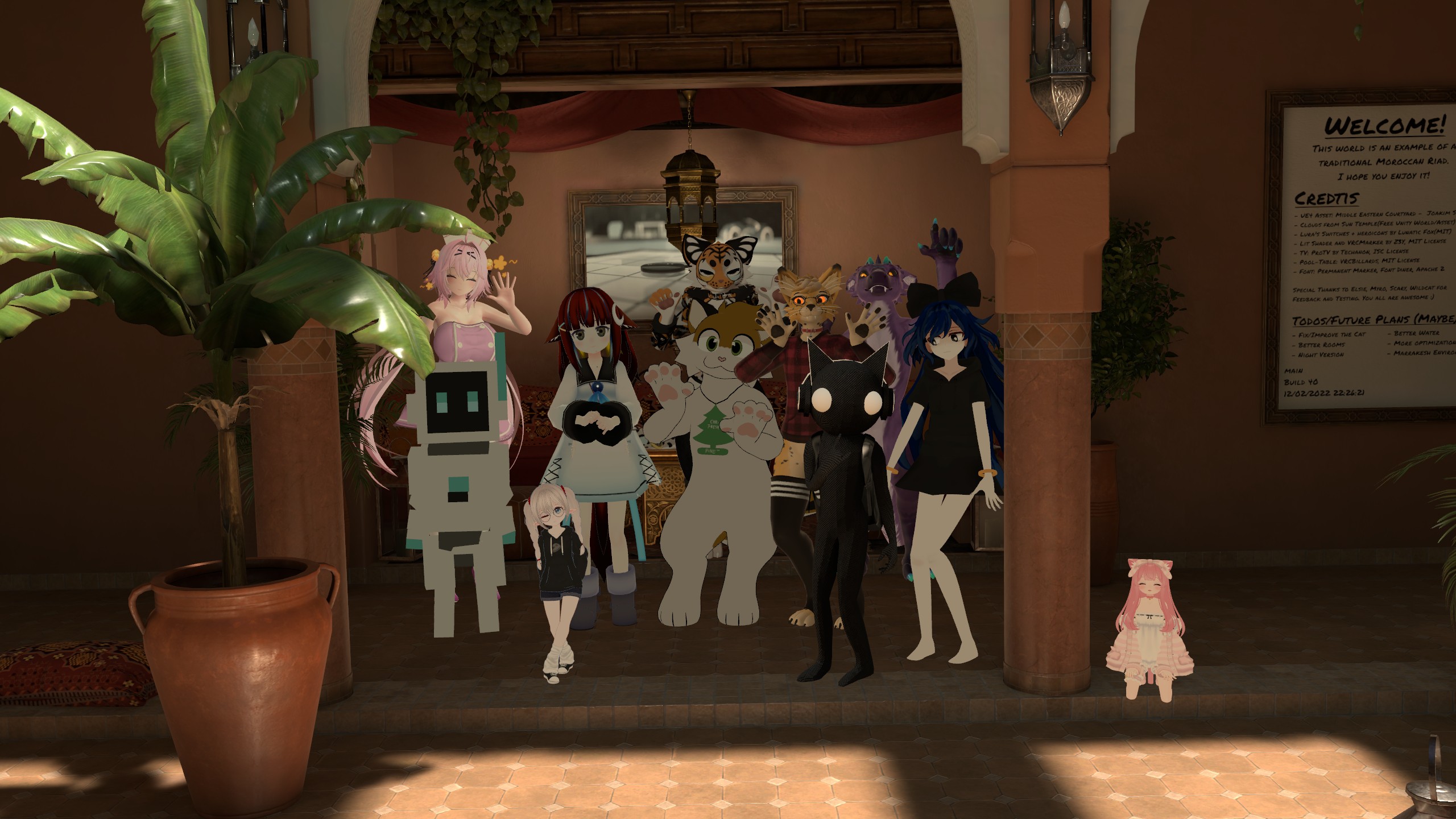 The image shows a diverse group of anime-style avatars posing together in an open, Moroccan-inspired architectural space with warm lighting and decorative elements. Key elements: Setting: An arched entranceway with terracotta walls, wooden doors, hanging lanterns, potted plants (including a large palm tree on the left), red curtains, rugs, and a 'Welcome!' signboard on the right crediting world creators with details on credits, todos, and future plans dated 10/06/2022. Avatars (from left to right): Pink-haired girl in a revealing nurse outfit with cat ears and tail, holding her hands up playfully; Red-haired girl with cat ears, smiling; Tall robotic figure (mecha) with screens for eyes, next to a short girl in black hoodie and loose socks; Fluffy white cat-seal furry waving paws excitedly; A jaguar-like furry in plaid shirt; Black cat-like huanoid with large white eyes and headphones; Dark blue-haired Yorigami-Shion-like girl wearing a black ribbon and dress with gold bracelets; 
Purple furry with cyan nails; Small pink-haired lolita-style girl sitting on the floor in frilly dress. The scene has a welcoming, festive vibe from VRChat, with sunlight streaming in and a playful group dynamic.